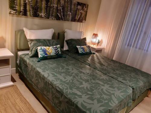 a bed with two pillows on it in a bedroom at Les Cerisiers The Cherry Trees in Flic-en-Flac