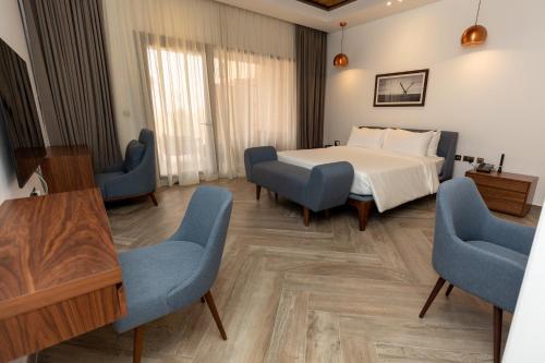 a bedroom with a bed and chairs and a table at Bab Al Nojoum Bateen Liwa in Liwa