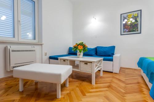 een woonkamer met een blauwe bank en een tafel bij Chic Apartment in Center in Split