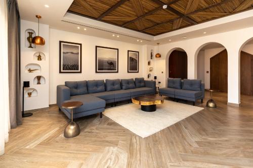 a living room with a blue couch and a table at Bab Al Nojoum Bateen Liwa in Liwa