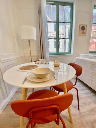 une table blanche avec deux chaises et une table avec une lampe dans l'établissement Le Cocon du Robec, à Rouen