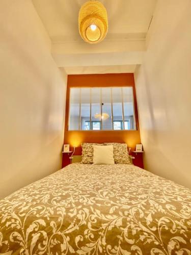 une chambre avec un grand lit avec une fenêtre dans l'établissement Le Cocon du Robec, à Rouen