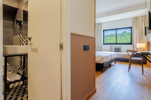 a room with a bed and a room with a door at Hotel Acta Madfor in Madrid