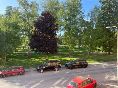 un gruppo di tre auto parcheggiate in un parcheggio di Apartment Garbo a Stoccolma