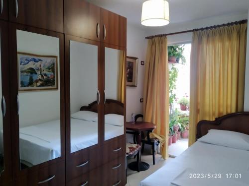 - une chambre avec deux lits et une grande armoire en bois dans l'établissement Holiday apartment Shengjin, à Shëngjin