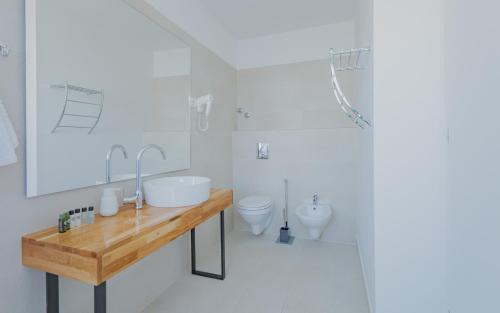 a white bathroom with a sink and a toilet at Monvidal by Bura Hotels - Adults Only in Pula