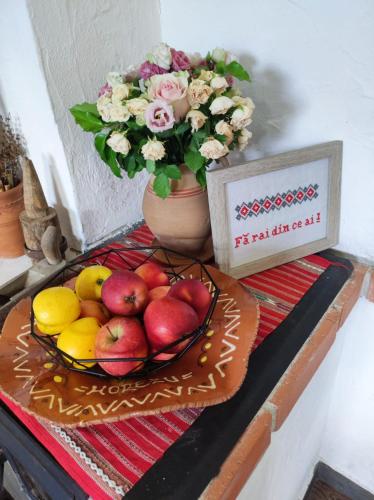 Ograda Bunicilor في بايا دي فيير: صحن من الفاكهة على طاولة مع إناء من الزهور