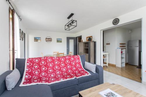 - un salon avec un canapé bleu et une couverture rouge dans l'établissement Les Arolles - Appartement vue sur la montagne, à Saint-Léger-les-Mélèzes