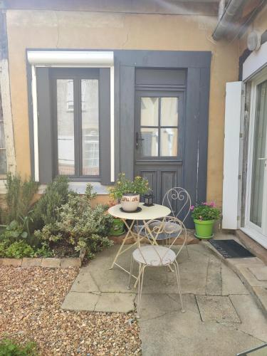 un patio con mesa y sillas frente a una puerta en Chambre d hote, en Bonnétable