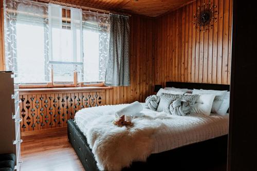 een slaapkamer met een bed met een wit dekbed bij Tatra House in Poronin