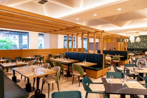 a restaurant with wooden tables and chairs and tablesktop at Puerto Antilla Grand Hotel in Islantilla