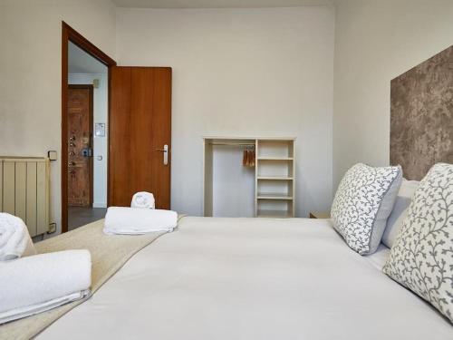 a bedroom with a large white bed with pillows at Bed&BCN Arquimedes Barcelona in Barcelona