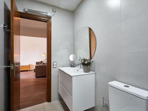 W łazience znajduje się umywalka, lustro i toaleta. w obiekcie Bed&BCN Arquimedes Barcelona w Barcelonie