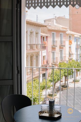 a table with a coffee cup sitting on top of a balcony at Castelar Palace & SPA by Seaward Suites in Villajoyosa
