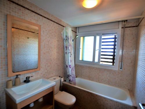 baño con lavabo y aseo y ventana en Villa Alzina9 pax Lloret de mar, en Vidreres
