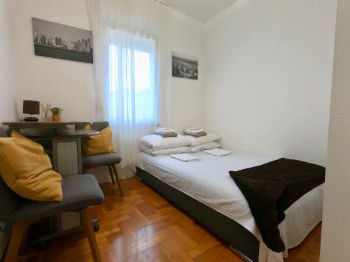 una camera con letto, scrivania e sedia di Sunny apartment by the beach a Kaštel Štafilić