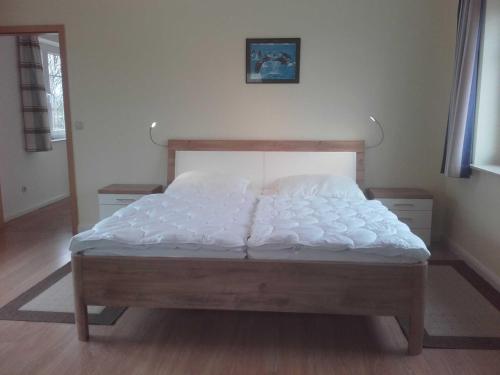 1 dormitorio con 1 cama grande con sábanas blancas en Ferienhaus Berger, en Timmendorfer Strand