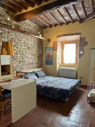 a bedroom with a bed in a room with a stone wall at La Conchiglia in Scarlino