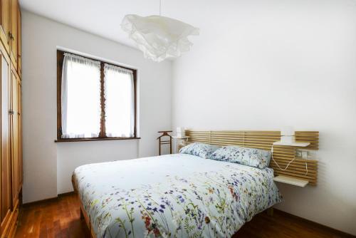 a white bedroom with a bed and a window at il larice d' oro in Sueglio