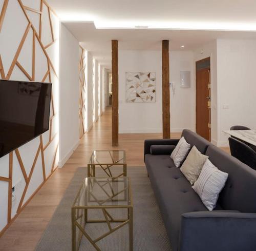 ein Wohnzimmer mit einem blauen Sofa und einem TV in der Unterkunft Luxury flat Chamberi II in Madrid
