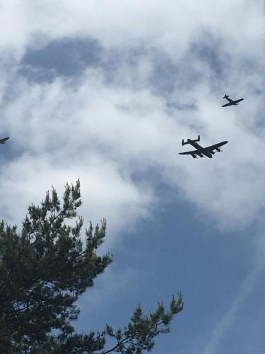 two planes are flying in the cloudy sky at Jasmine The Shepherd Hut in Woodhall Spa