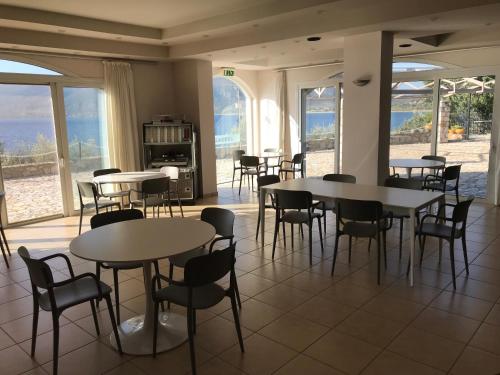 un comedor con mesas, sillas y ventanas en Annema Hotel and Restaurant, en Monemvasia