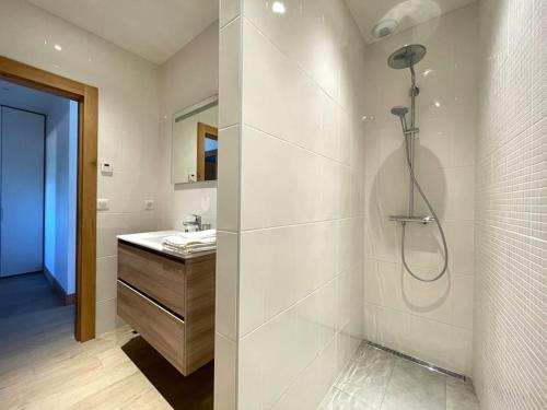 La salle de bains blanche est pourvue d'une douche et d'un lavabo. dans l'établissement Bord de Mer - Adorable maison au calme - 6 pers., à Biarritz