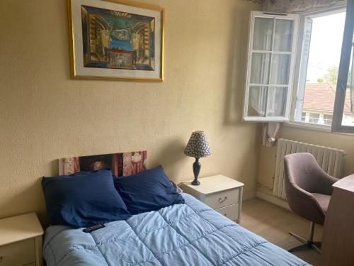 - une chambre avec un lit doté de draps bleus et une fenêtre dans l'établissement villeparis 2 chambres séparées, à Villemoisson-sur-Orge
