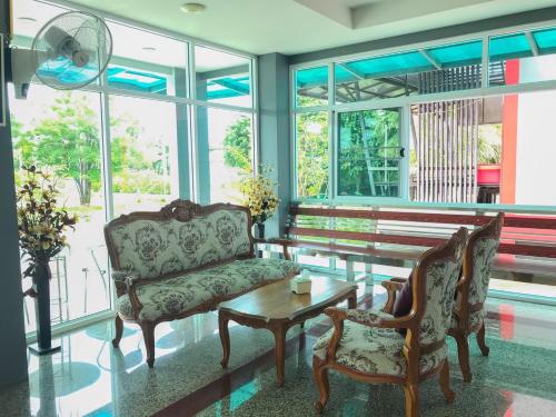 a living room with a couch and a table and chairs at โรงแรมสบาย พาเลซ in Nakhon Si Thammarat