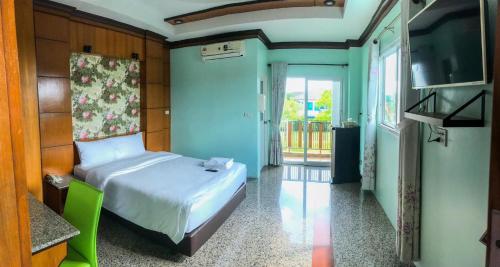 a small bedroom with a bed and a television at โรงแรมสบาย พาเลซ in Nakhon Si Thammarat