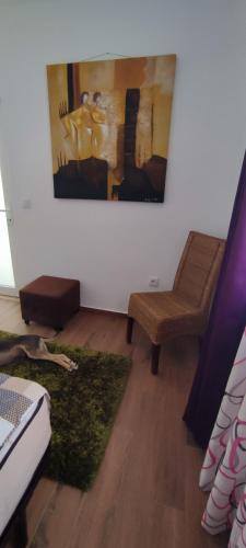a living room with a chair and a painting on the wall at Kyrios Lounge Studio with use of private pool in Carrascal