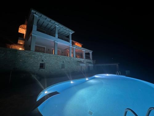a swimming pool in front of a house at night at Endless Blue in Anavissos