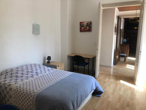 1 dormitorio con cama, escritorio y mesa en Metz-sud - Appartement 120 m2 dans maison du XVIII - Jouy aux Arches entre Nancy et Luxembourg - Proximité toutes commodités, en Jouy-aux-Arches