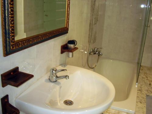 y baño con lavabo, ducha y espejo. en Casa Rural Outeiro, en Outeiro
