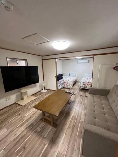 a living room with a large flat screen tv at 駅徒歩２分の貸切一軒家【Villa Kokusai】 in Naha