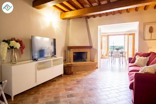 a living room with a television and a fireplace at Il Petruccaio by TuscanyWeGo in Orceto