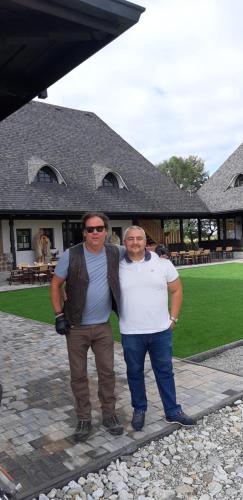 two men posing for a picture in front of a house at Ograda Bunicilor in Baia de Fier