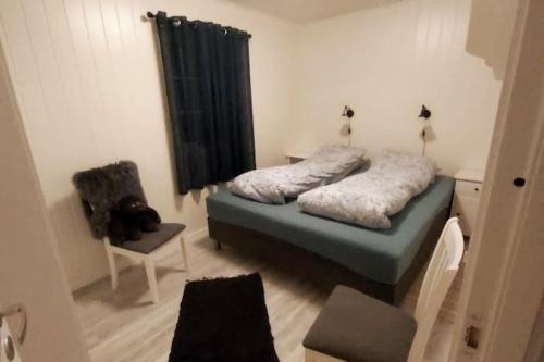 a small bedroom with a bed and a chair at Frittliggende hytte ved Indalsälven i Duved - Åre in Duved