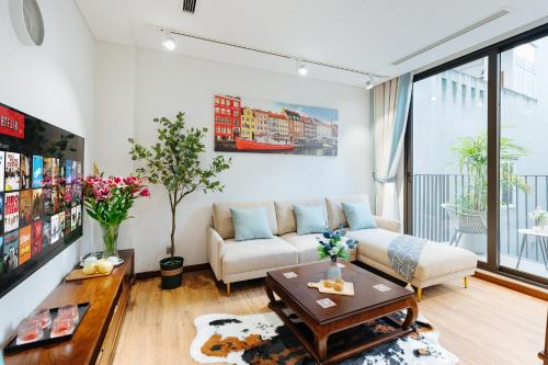 a living room with a couch and a table at Margaery Boutique Apartment & Skyon9 Rooftop Bar in Hanoi