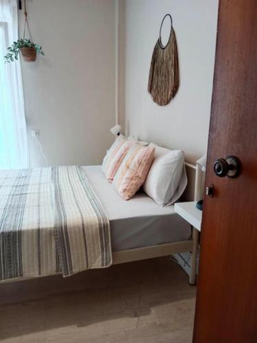 um quarto com uma cama com almofadas cor-de-rosa e brancas em Cherry - HappyHostGr - Downtown Apartment em Volos