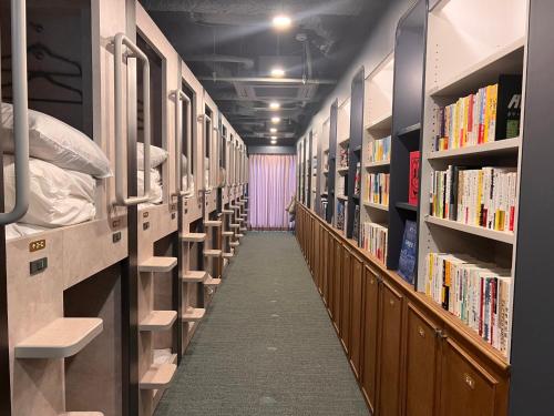 a hallway of a library with rows of books at Book Tea Bed SHIBUYA in Tokyo