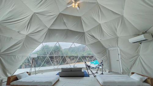 a tent with two beds in a room with a window at glampark resort Akuna beach in Henza
