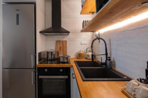 a kitchen with a sink and a refrigerator at Adela's 1 BR & Living room in Athens