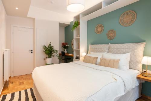 a bedroom with a large white bed with a blue wall at Adela's 1 BR & Living room in Athens