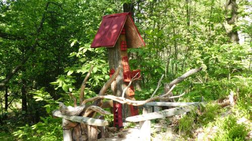 a small house on a tree stump with a fence at Cascina Marasca Appartamento Viola in Martina Olba