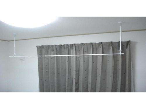 a shower curtain hanging from a rod in a bathroom at 2-10-15 Imagawa - Apartment / Vacation STAY 7905 in Tokyo