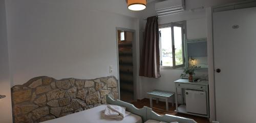 a bedroom with a stone wall and a bed and a window at Elia in Skala