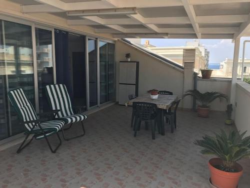 a patio with chairs and a table on a balcony at Coral Bay Suite Gallipoli in Gallipoli