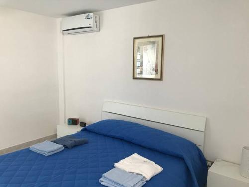 a bedroom with a blue bed with two towels on it at Coral Bay Suite Gallipoli in Gallipoli