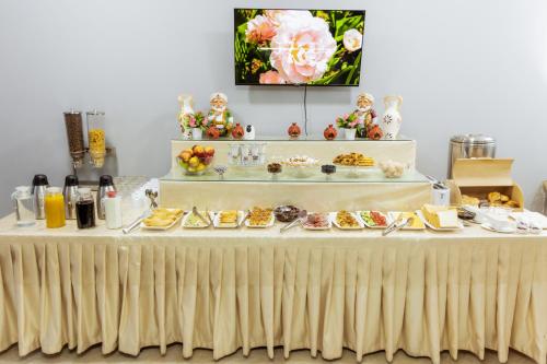 een tafel met daarop een buffet met eten bij Stella Hotel Tashkent in Tasjkent
